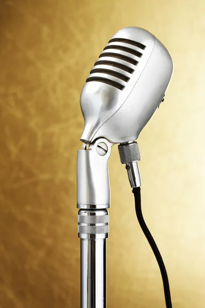 Retro style microphone. Gold background