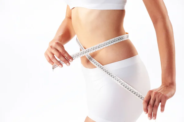 Woman measuring her abdomen with a meter-stick — Stock Photo, Image