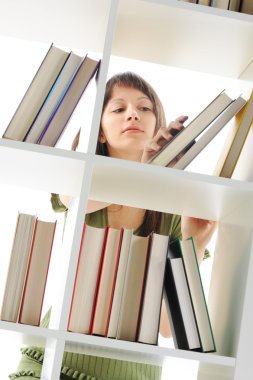 Young Woman looking for a book at the library , similar photo on clipart