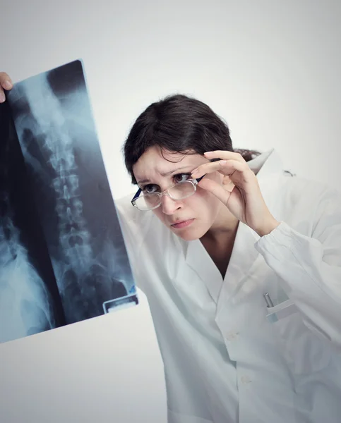 Médica feminina olhando para um raio-x (foto humor ) — Fotografia de Stock