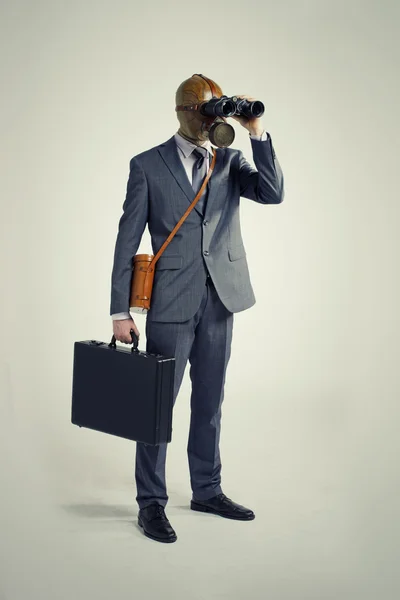 Podnikatel s plynovou masku při pohledu dalekohledem — Stock fotografie