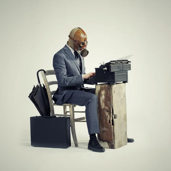 Business wearing a gas mask, write with an old typewriter — Stock Photo, Image