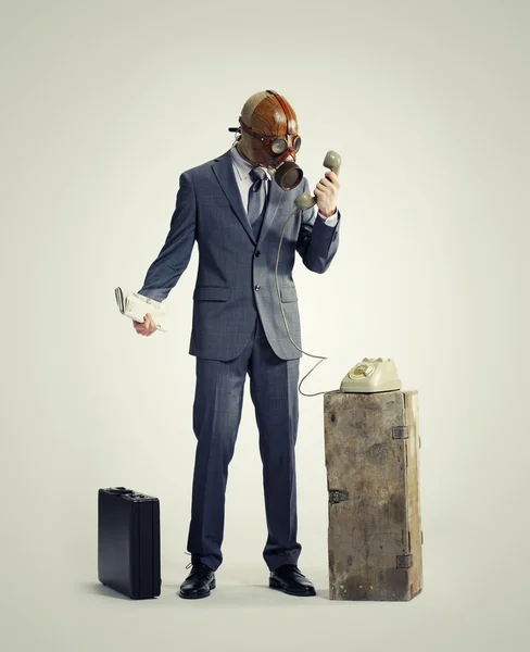 Businessman with gasmask at phone — Stock Photo, Image