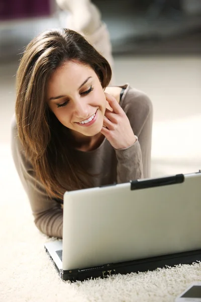 웃는 여자는 거실에서 그녀의 노트북을 사용 하 여. — 스톡 사진