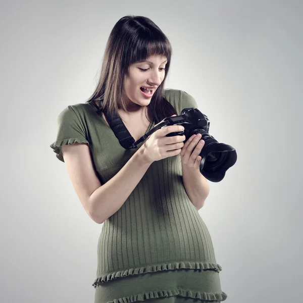 A young girl holds up a camera. — Stock Photo, Image
