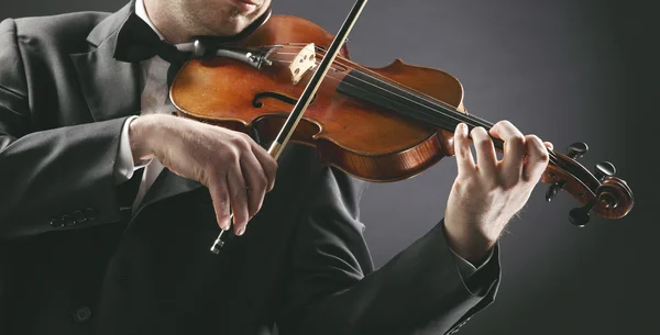 Скрипаль: музикант грає на скрипці на темному фоні — стокове фото