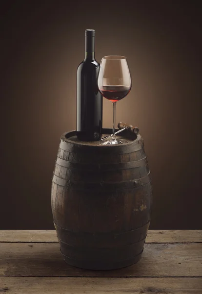 Κόκκινο φιάλη κρασιού και το ποτήρι του κρασιού σε βαρέλι ξύλινο — Φωτογραφία Αρχείου