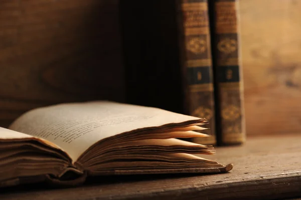 Vieux livre ouvert sur une table en bois — Photo