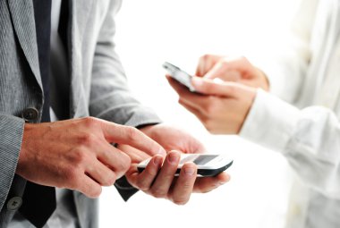 Businesspeople text message on their mobile phones clipart