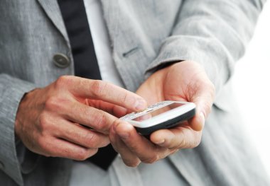 Businesman with a smart phone, Closeup of hands clipart