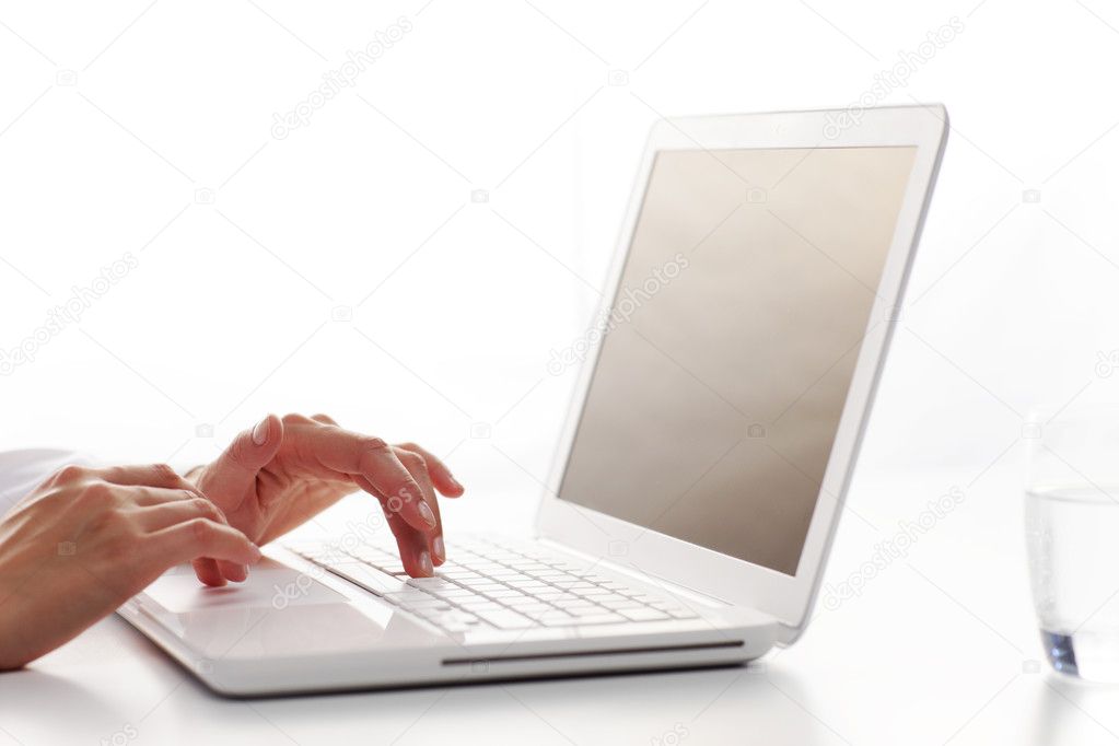 Female hands typing on a white computer keyboard