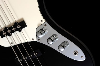 Close up of a black electric bass glossy on dark background clipart