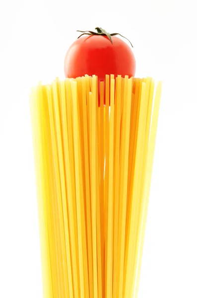 Ongekookte spaghetti noedels. Italiaanse pasta met tomaten — Stockfoto