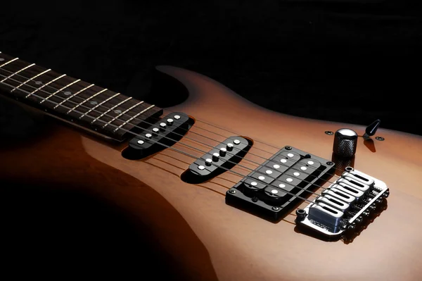 Primo piano di una chitarra elettrica su sfondo scuro — Foto Stock