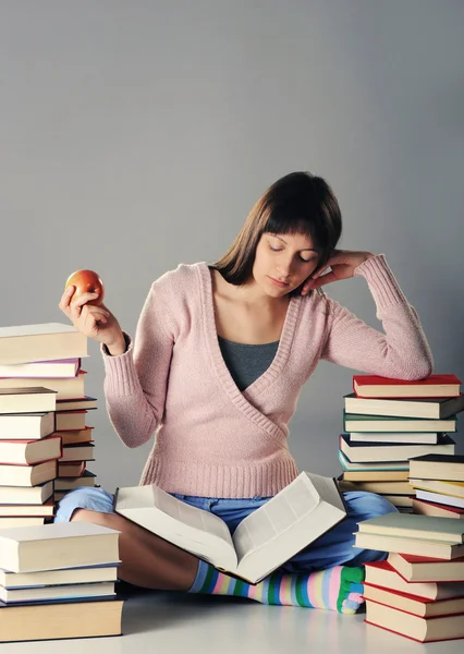 Menina bonito estudar com uma grande pilha de livros — Fotografia de Stock