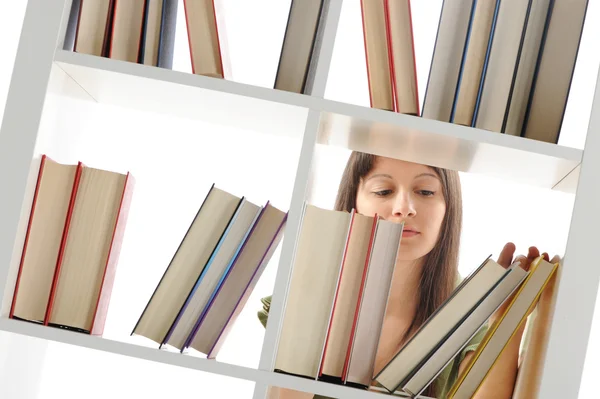 Mladá žena hledá knihu v knihovně, podobné fotografie — Stock fotografie