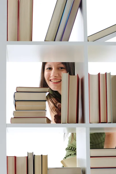 Mulher jovem à procura de um livro na biblioteca, foto semelhante em — Fotografia de Stock