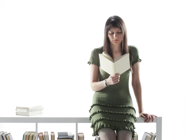 Νεαρή γυναίκα με μακριά μαλλιά, κρατώντας ένα ανοιχτό βιβλίο, θα διαβάσετε κατά τ — Φωτογραφία Αρχείου