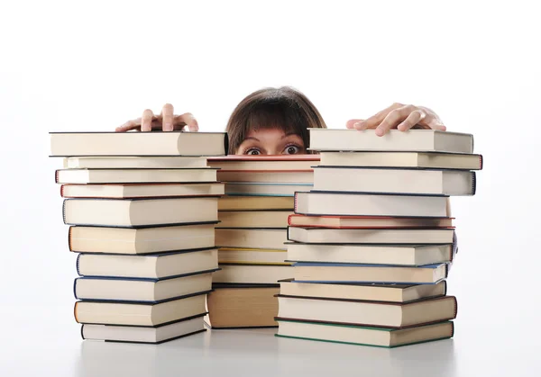 Giovane donna dietro una grande pila di libri — Foto Stock