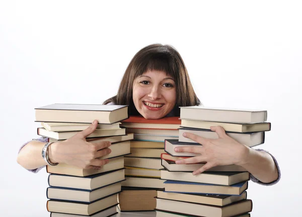 Jonge vrouw achter een grote stapel boeken — Stockfoto