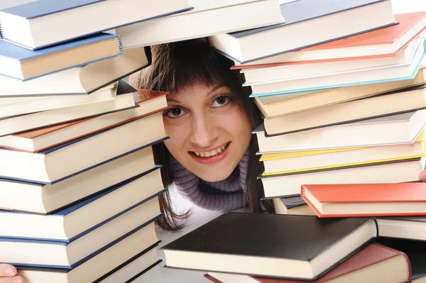 Νεαρή γυναίκα πίσω από ένα μεγάλο σωρό των βιβλίων — Φωτογραφία Αρχείου