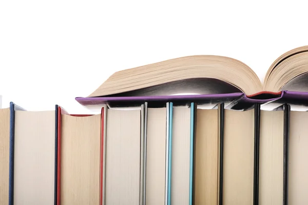 Libro aperto poggiante su pila di libri.sfondo bianco — Foto Stock