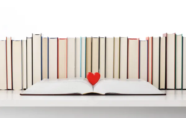 Книги кохання, відкрита книга з серцем, купа книг на фоні — стокове фото