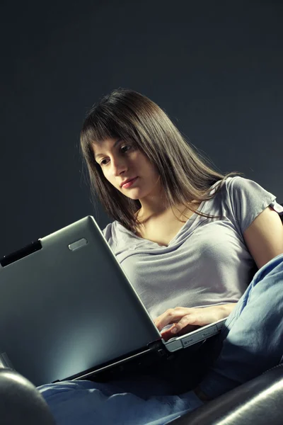 Dizüstü bilgisayar kullanan genç bir kadın — Stok fotoğraf
