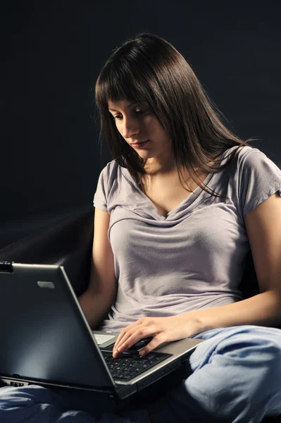 Ung kvinna att skriva på ett tangentbord laptop — Stockfoto
