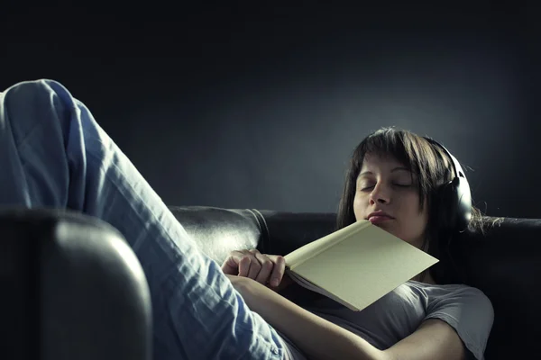 轻松年轻女子躺在沙发时听音乐的 headp — 图库照片