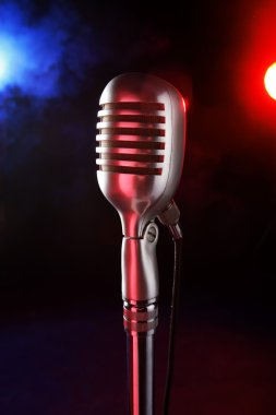 Old microphone on a dark background and smoky clipart