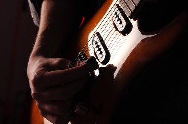 Rock guitarist on black background clipart