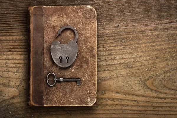 Antique Padlock with key on old book — Stock Photo, Image