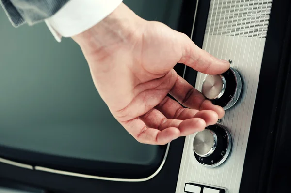 Man turning channel knob — Stock Photo, Image