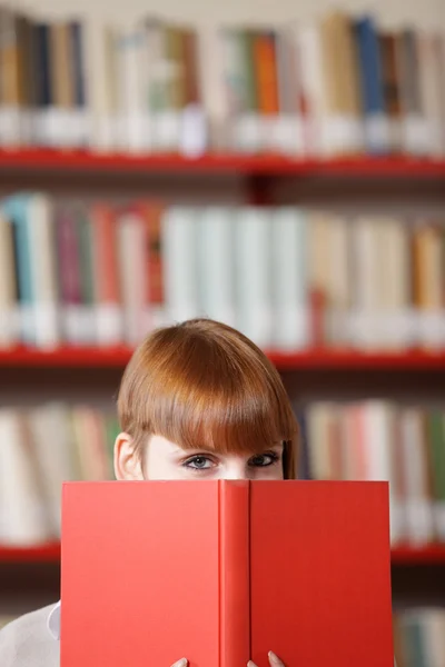 Jonge student in een bibliotheek — Stockfoto