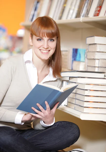 Unga collegestudent i ett bibliotek — Stockfoto