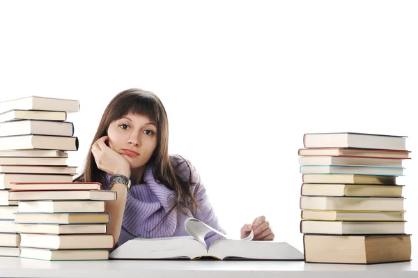 Cansada de estudos, a jovem mulher está sentada em sua mesa com livros — Fotografia de Stock