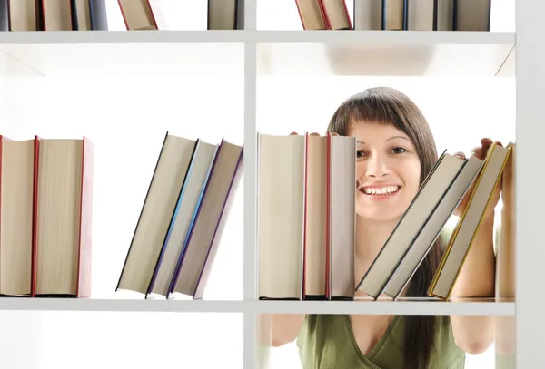 Mujer joven buscando un libro en la biblioteca — Foto de Stock