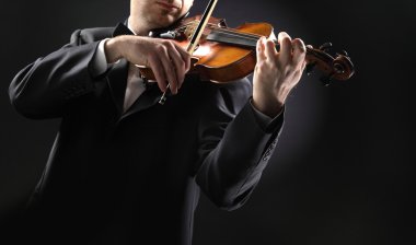 The violinist: Musician playing violin on dark background clipart