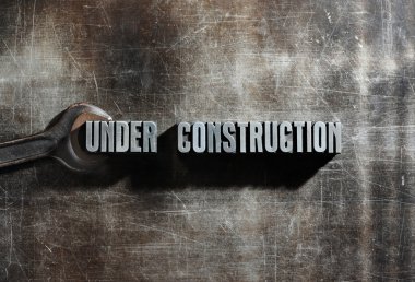 Image of a Under Construction sign with a metallic background te clipart