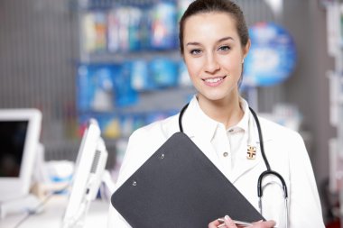 At pharmacy. A smiling young woman pharmacist wearing stethosco clipart