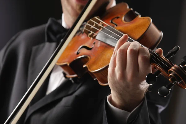 Houslista: hudebník hrající housle na tmavém pozadí — Stock fotografie