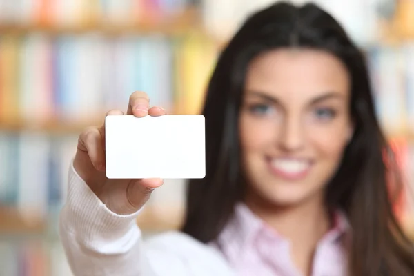 Leende ung kvinna visar ett visitkort - kopia utrymme. — Stockfoto