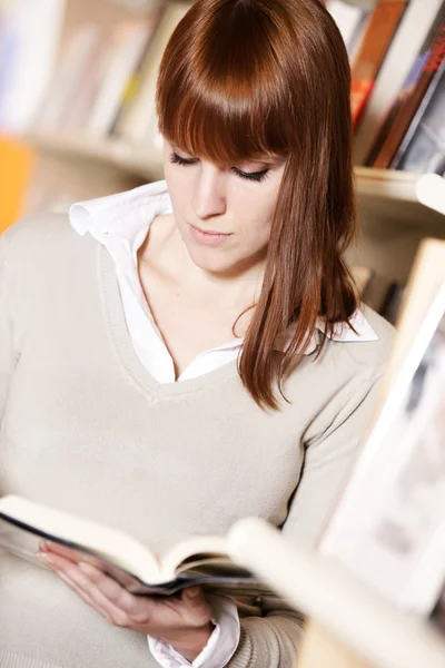 Junge Studentin in einer Bibliothek — Stockfoto