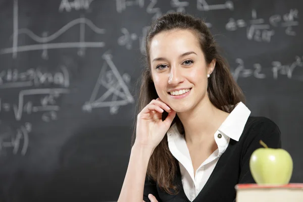 Porträt einer jungen Frau, Lehrerin vor einer Tafel — Stockfoto