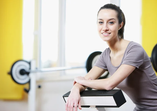 Bella ragazza sportiva sorride e riposa in una palestra . — Foto Stock