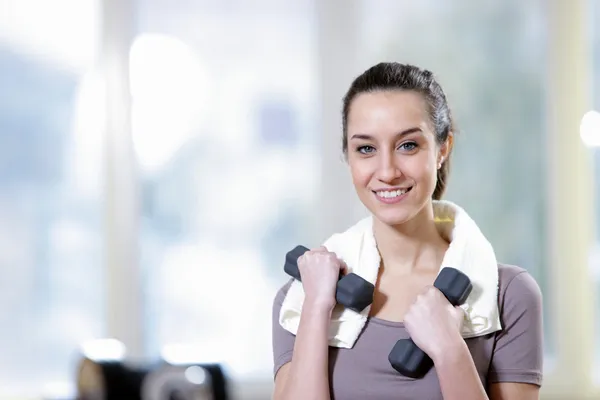 Dumbbell in hand of working out young smiling female — Stock Photo, Image