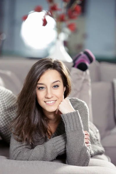 Portrait of a beautiful young woman lying on couch — Stock Photo, Image