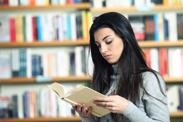 Studentin liest in Bibliothek ein Buch — Stockfoto