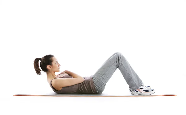 Fitness vrouw doen fitness oefening op mat. witte achtergrond — Stockfoto